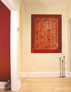 Wall hanging by Debra Gould provides a dramatic focal point in this foyer.